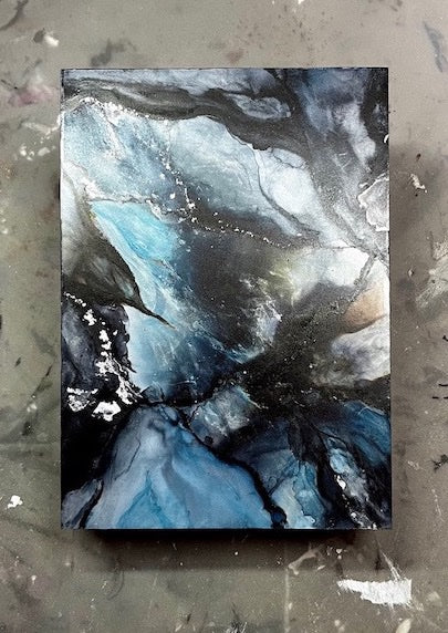 Blue wall art with an all-over marble effect set on a grey backdrop. This abstract painting expresses emotion and metamorphosis as a soul message.