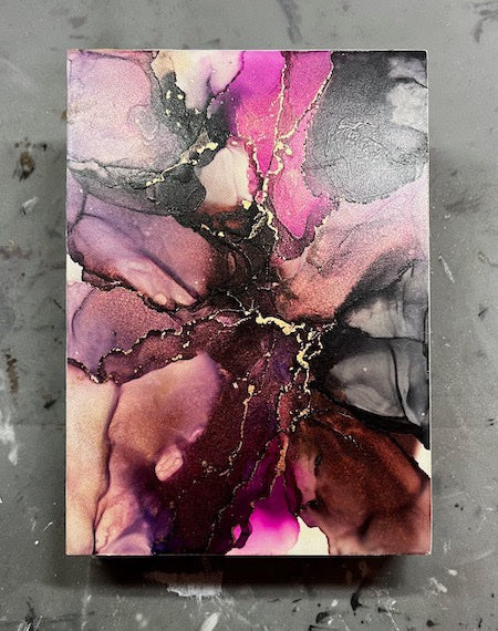 Abstract space art with pink, purple, black, copper and gold colours on a textured grey background.