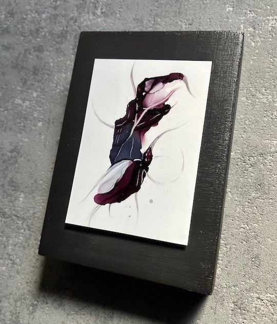 Symbolism art in a dark aesthetic featuring animal hybrid elements and deep colours of purple and blue. This original art is set on a black panel and hung in a grey interior room.