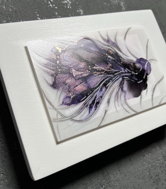 Symbolism art of transformation featuring a hybrid animal in purple and black colours. This transformation artwork is set on a white panel that is hung on a grey wall.