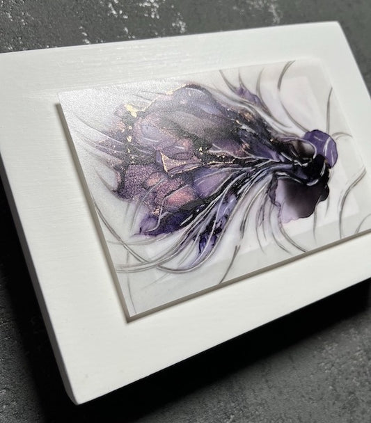 Symbolism art of transformation featuring a hybrid animal in purple and black colours. This transformation artwork is set on a white panel that is hung on a grey wall.