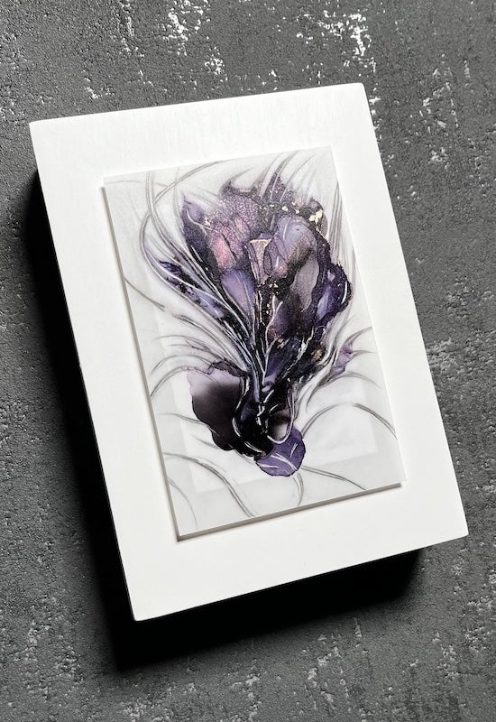 Transformation artwork of an animal hybrid where elements of flora and fauna have been painted in a dark aesthetic of purple and black. Symbolic of change through darkness, depth and emotion, this original art is mounted on a white panel and is displayed on a grey wall.
