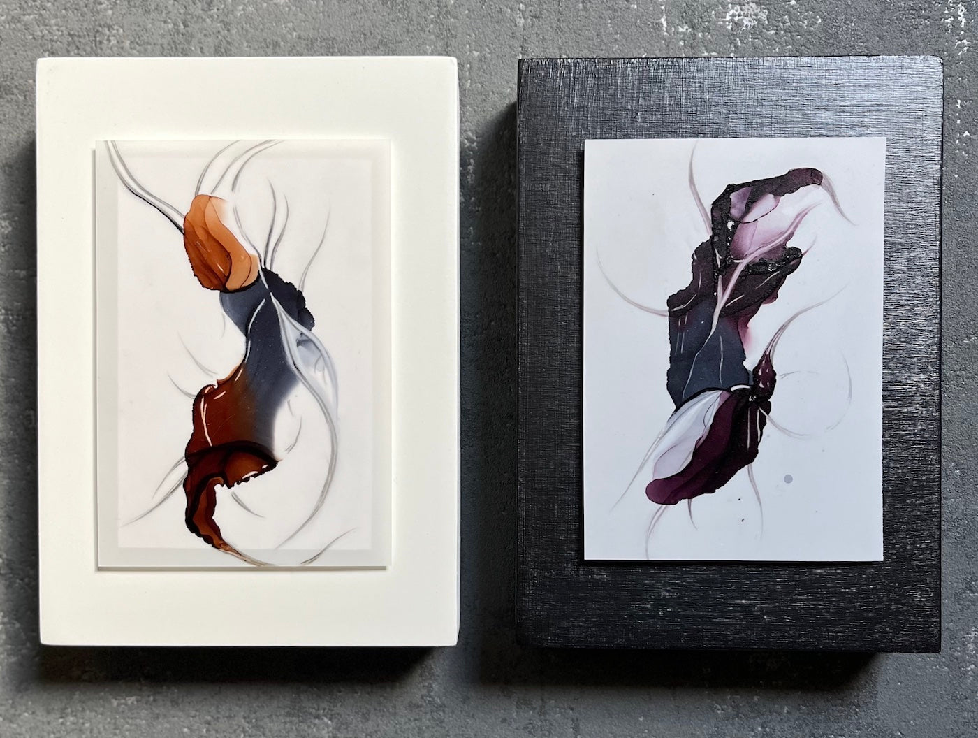 Two surreal abstracts on a grey wall.